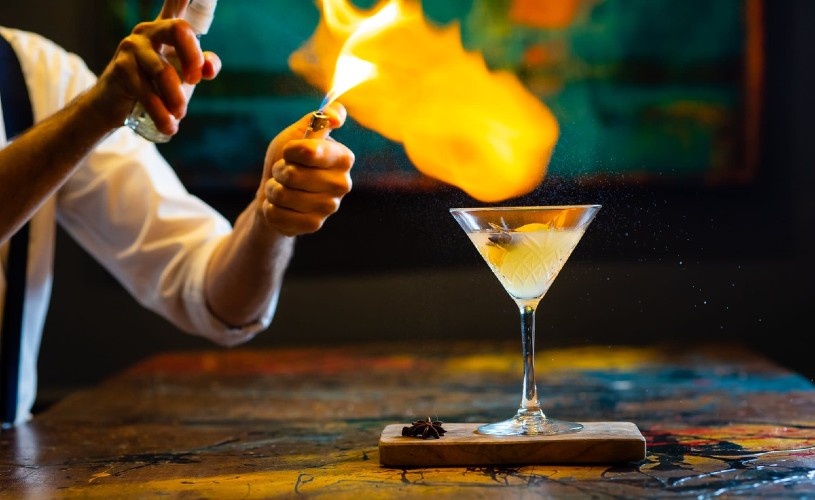 Bartender using fire to make a cocktail at Abbey Hotel's ArtBar